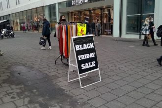 Aufsteller mit der Aufschrift Black Friday Sale in einer Fußgängerzone