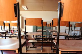 Leeres Klassenzimmer mit hochgestellten Stühlen auf den Tischen