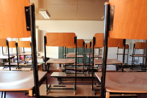 Leeres Klassenzimmer mit hochgestellten Stühlen auf den Tischen