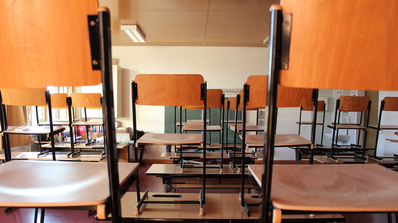 Leeres Klassenzimmer mit hochgestellten Stühlen auf den Tischen