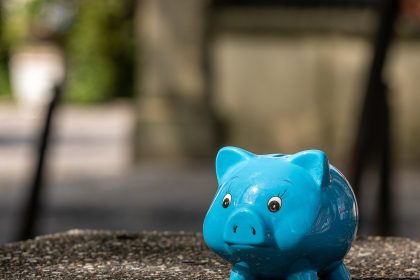 Blaues Sparschwein auf einer Steinmauer – Symbolbild für die Frühstartrente