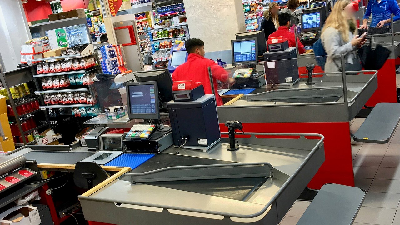 Kassenbereich eines Supermarkts mit mehreren Kassen – typischer Arbeitsplatz für Minijobs
